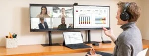 MSFT Woman using Surface device and two monitors while in virtual meeting